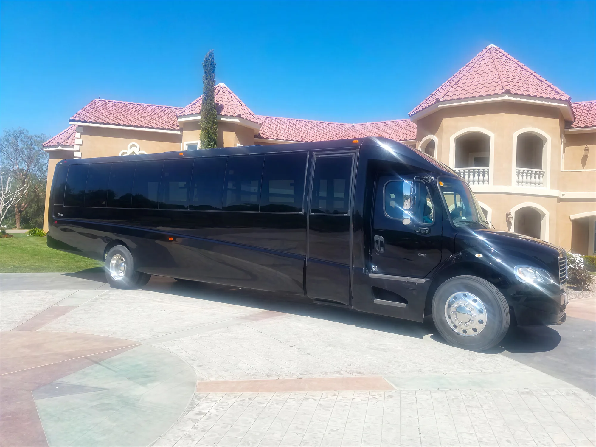 Black luxury party bus for Temecula wine country tours parked near vineyard estate