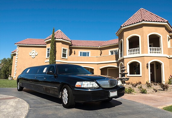 A black, stretch limousine in front of a tan building in Southern California